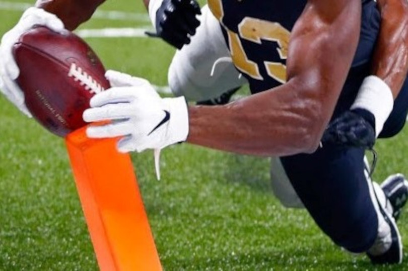 A football player is holding onto an orange flag.