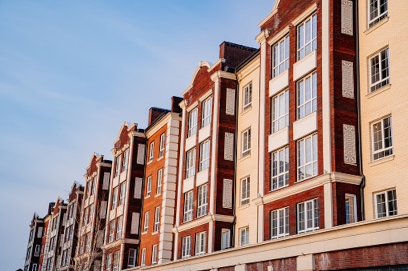 A row of buildings with windows and balconies.