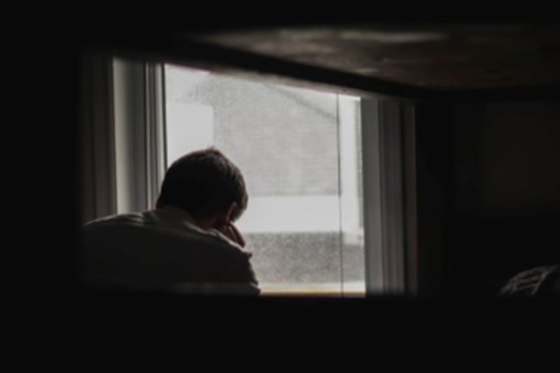 A person sitting in front of a window.