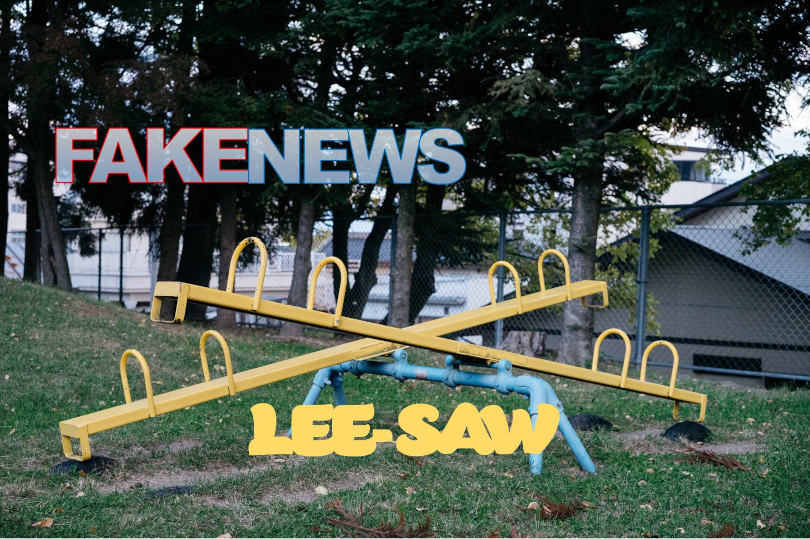 A yellow and blue swing set with fake news written on it.