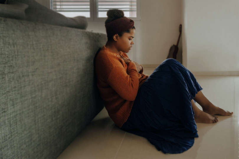 A woman sitting on the couch looking at her phone.