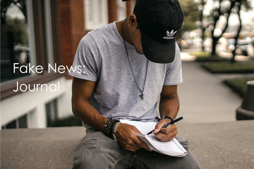 Man writing in journal outdoors.