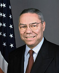 Smiling man in front of American flag.