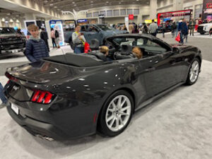 Black convertible car at an auto show.