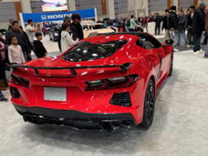 Red sports car at auto show event.