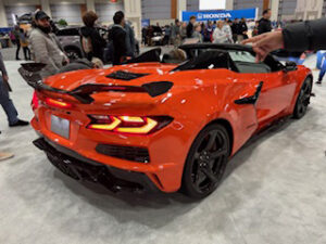 Bright orange sports car at auto show.