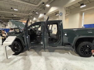 Green pickup truck with open doors.