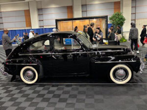 Classic black car displayed at an event.