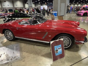 Red vintage sports car at an auto show.