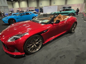 Red sports car on display at event.