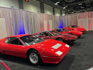 Four red classic cars on display.