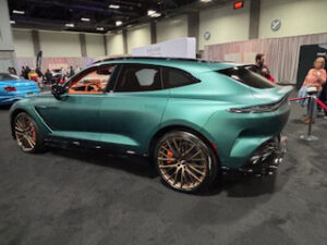 Sleek green SUV with gold rims.