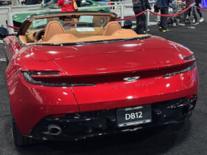 Red convertible sports car at auto show.