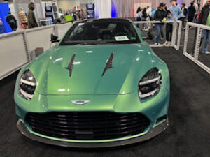 Green Aston Martin sports car at an event.