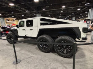 Six-wheeled truck at auto show display.