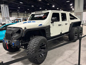 Modified white six-wheeled pickup truck.