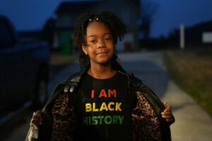 Young girl wearing "I Am Black History" shirt.