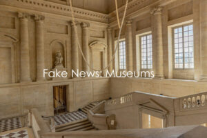 Grand museum interior with statue and windows.