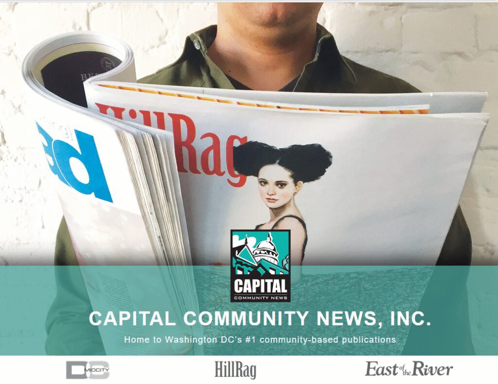 Person holding magazines with Capital News logo.