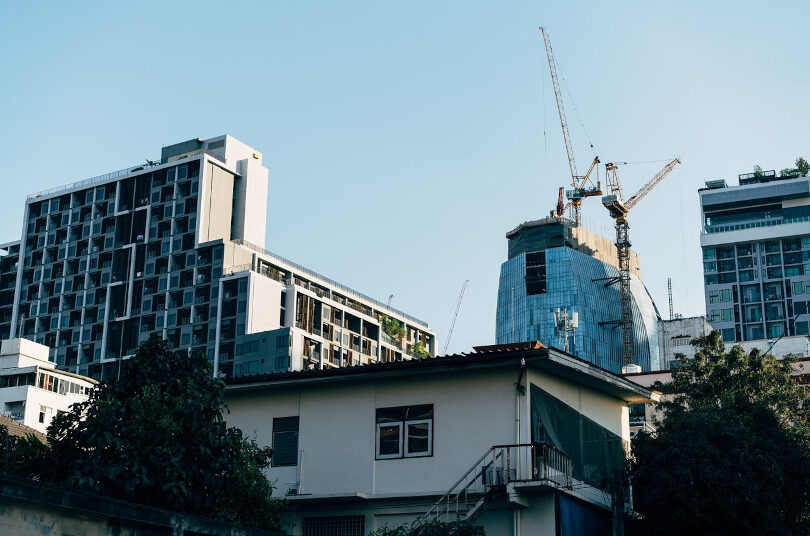 Urban skyline with cranes and buildings.
